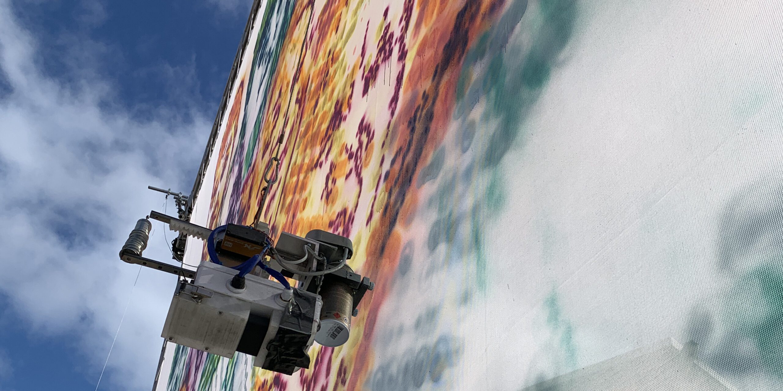A close-up of the robot spray painting the canvas