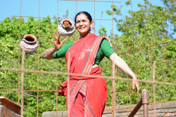A performer holding a piece of clay that their are going to use in a their dance performance called Lives of Clay.
