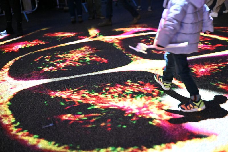 An image of a child walking across a decorative and colourful floor