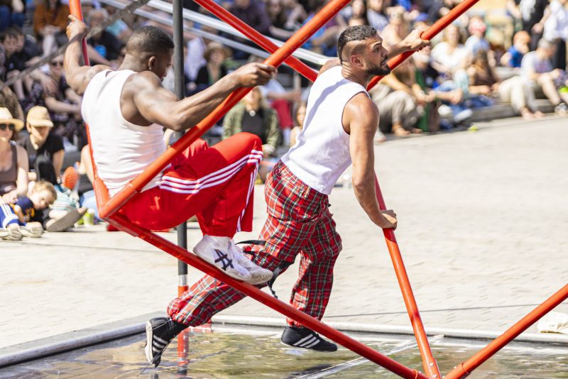 An image of two male dancers suspended in a cube shaped frame