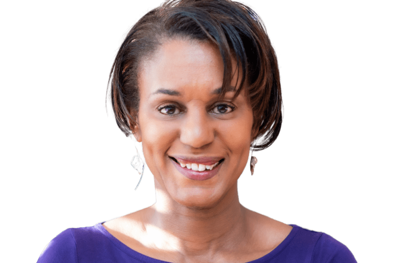 An image of a woman with short dark hair facing the camera wearing a blue top and earrings.