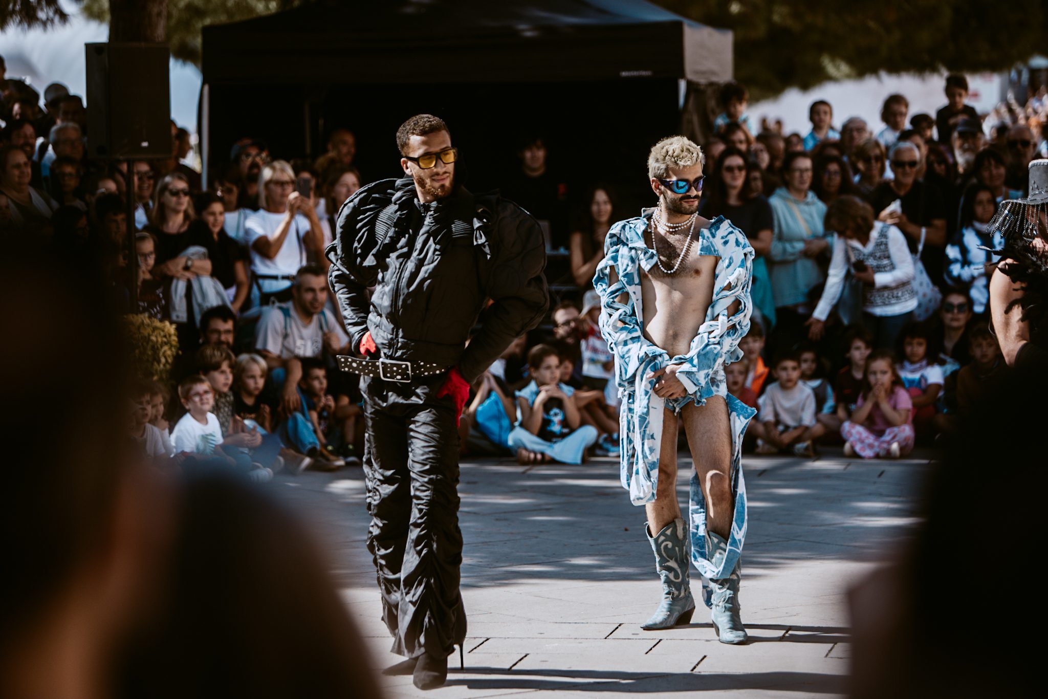 An image of 2 male street performers surrounded by a crowd.