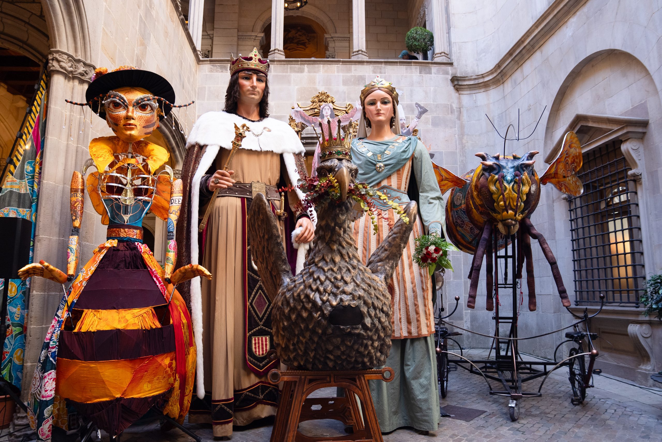 An image of 5 large scale puppets. There are 2 bees, a chicken and a male and female dressed in regal clothing.