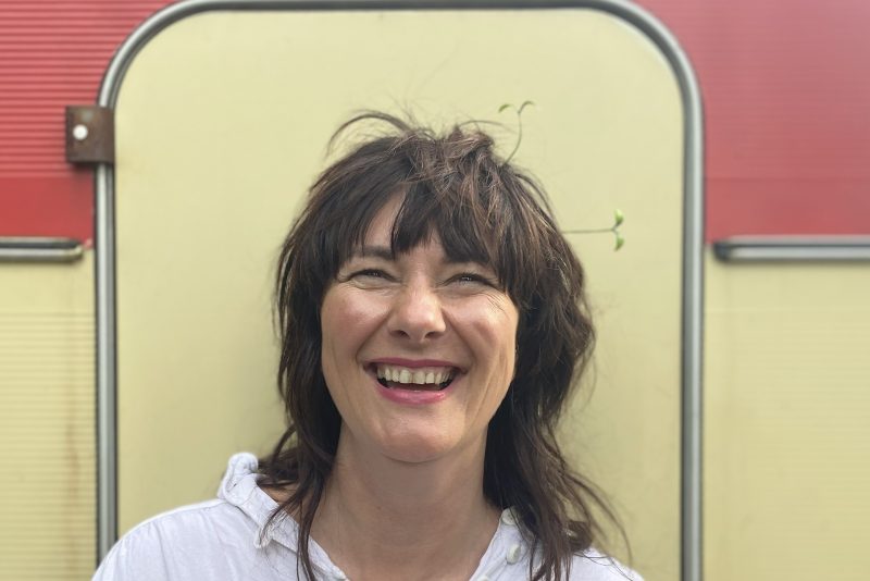 A portrait image of a woman with long dark hair smiling.